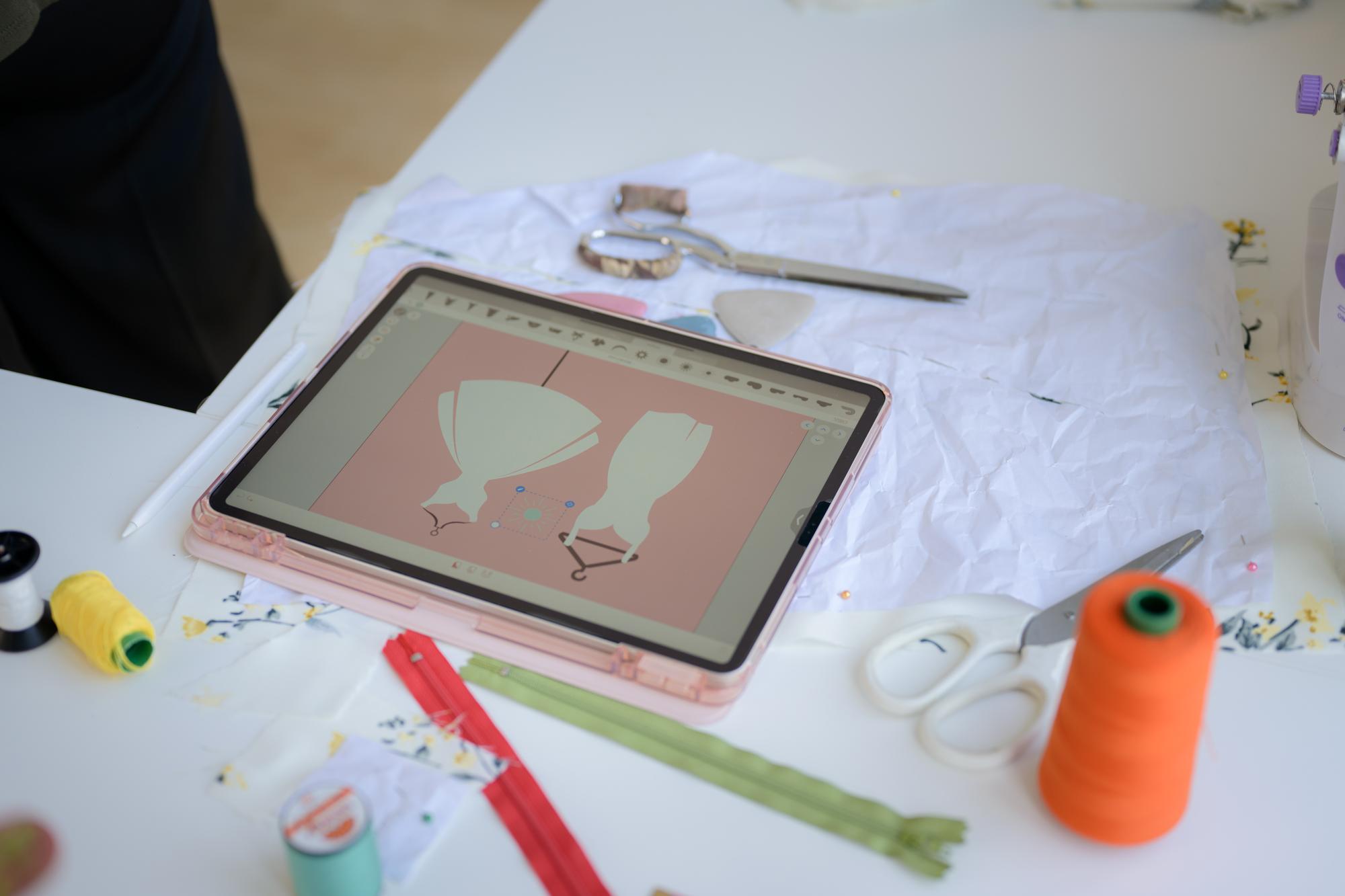 studio workspace with embroidery tools and tablet